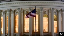 Bendera Amerika Serikat tampak terpasang di depan gedung Capitol Hill yang menjadi markas dari kongres AS. (Foto: AP/J. David Ake)