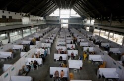 Senior citizens receive the Sinopharm coronavirus vaccine from health workers at a vaccination site in Lahore, Pakistan, March 18, 2021.