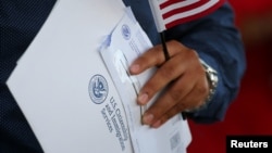 FILE - A newly naturalized U.S. citizen leaves a swearing in ceremony in Los Angeles, U.S., July 18, 2017. 