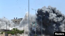 Asap mengepul dari sebuah ledakan yang menurut seorang saksi disebabkan oleh serangan udara Israel di Gaza City (23/8).