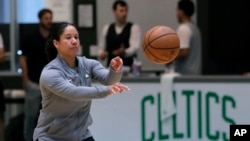 FILE - In this July 1, 2019, file photo, Boston Celtics assistant coach Kara Lawson passes the ball at the team's training facility in Boston. 