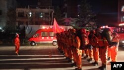 Firefighters stand to attention in Longnan, in China's Gansu province on Aug. 8, 2017, as they prepare to head to Wenxian county after an earthquake centered in neighboring Sichuan province. 