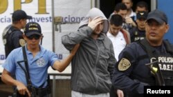 Police in Tegucicalpa escort one of five Syrians ordered jailed after they were found to have used stolen Greek passports to enter Honduras, Nov. 20, 2015.