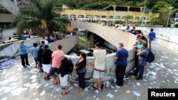 Brazilians stand in line outside a polling station to cast their votes in the presidential election, in Rio de Janeiro, Oct. 7, 2018.