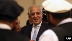 Perunding Amerika Zalmay Khalilzad (tengah) dan delegasi Taliban dalam perundingan di Doha, Qatar Juli 2019 lalu. 