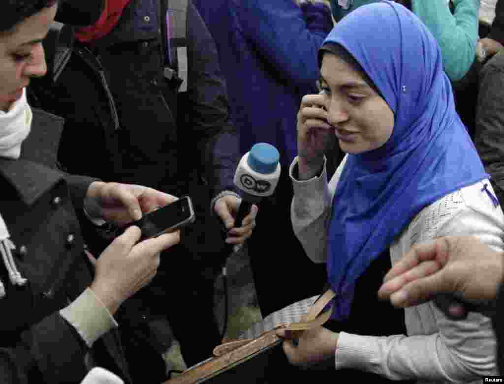 Jihan Rashed, wife of Al Jazeera journalist Baher Mohamed, calls her family before speaking to the media at a court in Cairo, Feb. 12, 2015.