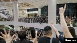 FILE - Pro-democracy demonstrators hold flags to call for independence during a vigil for a protester Marco Leung Ling-kit, who fell to his death during a demonstration outside the Pacific Place mall a year ago, in Hong Kong, China, June 15, 2020. 