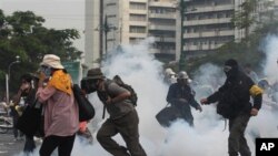 Polisi menembakkan gas air mata ke arah demonstran yang berusaha menerobos barikade (foto, 24/11/2012).