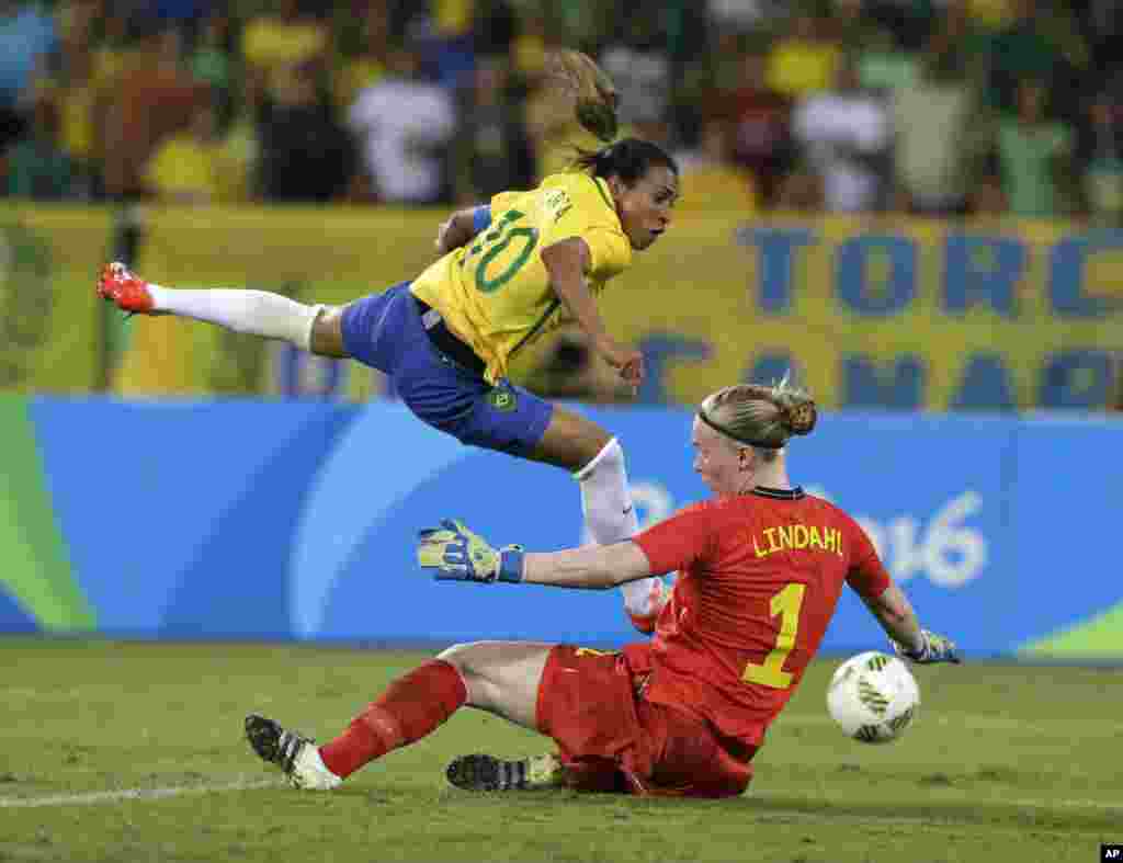 Brazil&#39;s Marta, left, leaps over Sweden goalkeeper Hedvig Lindahl as she attempts a shot on goal during a group E match of the women&#39;s Olympic football tournament between Sweden and Brazil at the Rio Olympic Stadium.