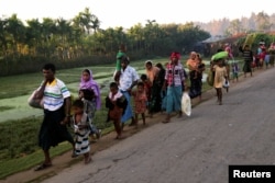 A group of Rohingya refugees, who fled last night from Myanmar by boat, walks toward a makeshift camp in Cox's Bazar, Bangladesh, Nov. 9, 2017.