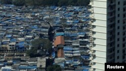 A high-rise residential building is seen next to a slum in Mumbai, India, Dec. 20, 2017.