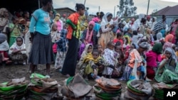 FILE - Displaced Ethiopians from different towns in the Amhara region wait for food to be distributed at lunchtime at a center for the internally-displaced in Debark, in the Amhara region of northern Ethiopia Aug. 27, 2021.