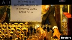 A goldsmith arranges wristbands at a shop at the Grand Bazaar in Istanbul, Turkey, Dec. 5, 2016. The sign on the window reads: Our sales are in Turkish Lira. If you have Dollar or Euro, come after exchange.