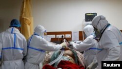 Petugas medis tengah merawat pasien Covid-19 di ruang intensif (ICU) Rumah Sakit Yatharth, Noida, dekat kota New Delhi, India, 15 September 2020. 