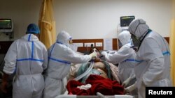 Medical workers take care of a patient suffering from the coronavirus disease (COVID-19), at the Intensive Care Unit (ICU) of the Yatharth Hospital in Noida, on the outskirts of New Delhi, India, Sept. 15, 2020. 