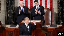 Predsednik Tramp sa stisnutom pesnicom dok potpredsednik Majk Pens i predsednik Predstavničkog doma Pol Rajan aplaudiraju