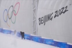 A worker shovels snow in preparation for freestyle ski and snowboard events at Genting Snow Park prior to the 2022 Winter Olympics, in Zhangjiakou, China, Jan. 31, 2022.