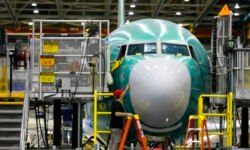 FILE - A worker inspects the nose cone of a Boeing 737 MAX airplane being built in Renton, Wash., Dec. 7, 2015.