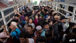 រូបថត​ដែល​ត្រូវ​បាន​ថត​កាល​ពី​ថ្ងៃទី៧ ខែកក្កដា ឆ្នាំ២០១៧ នេះ​បង្ហាញ​ពី​ពលករ​ចំណាកស្រុក​មីយ៉ាន់ម៉ា​​ដែល​ឆ្លង​ព្រំដែន​ថៃ​មីយ៉ាន់ម៉ា​តាម​រថយន្ដ​មួយ​គ្រឿង ខណៈ​ដែល​ពួកគេ​ចាកចេញ​ពី​ស្រុក Mae Sot ខេត្ត Tak ប្រទេស​ថៃ។ 