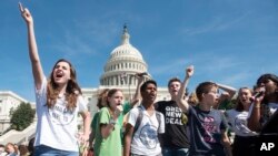 FILE - People who spoke on stage, gather to rally the crowd at the end of the Climate Strike protest, Sept. 20, 2019, in Washington.