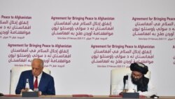 امریکہ کے نمائندہ خصوصی زلمے خلیل زاد اور طالبان رہنما ملا عبدالغنی برادر معاہدے پر دستخط کر رہے ہیں۔
