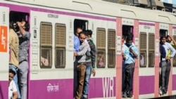 Commuters travel on a crowded local train in Mumbai, Feb. 1, 2022.