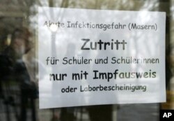 FILE - A sign at the entrance of a school in Freiburg, southern Germany, April 11, 2008, advises that only vaccinated children are allowed to enter.