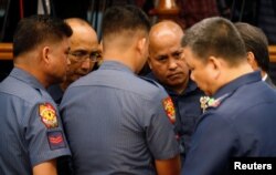 Philippine National Police chief Director-General Ronald dela Rosa (2nd-R) talks to fellow police officers during a Senate hearing regarding people killed during a crackdown on illegal drugs in Pasay, Metro Manila, Philippines, Aug. 23, 2016.