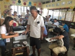 Seorang pria tua mencelupkan jarinya ke tinta setelah menyerahkan surat suaranya untuk pemilihan paruh waktu di sebuah TPS di Manila, Filipina 13 Mei 2019. (REUTERS/Jay Ereno)