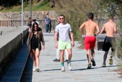 People walks near the beach during a nationwide confinement to prevent the spread of the coronavirus, in Biarritz, France, Saturday April 4, 2020.