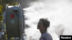 A supporter cools down after the match between Britain's Daniel Evans and Japan's Tatsuma Ito, Jan. 14, 2019, at the Australian Open in Melbourne, Australia.