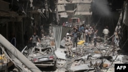 FILE - Destruction is seen following a reported barrel-bomb attack by Syrian government forces in the northern city of Aleppo.