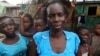 A woman poses for a photograph with her children in front of house in the slum of Makoko in Lagos, Nigeria, January 22, 2013