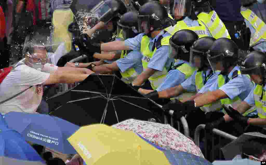 Riot police use pepper spray against protesters outside the government headquarters in Hong Kong.