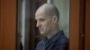 Wartawan Wall Street Journal Evan Gershkovich berada dalam bilik kaca dalam persidangan atas dakwaan spionase yang membelitnya di Yekaterinburg, Rusia, pada 26 Juni 2024. (Foto: Reuters/Evgenia Novozhenina)