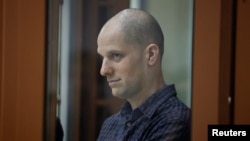 Wartawan Wall Street Journal Evan Gershkovich berada dalam bilik kaca dalam persidangan atas dakwaan spionase yang membelitnya di Yekaterinburg, Rusia, pada 26 Juni 2024. (Foto: Reuters/Evgenia Novozhenina)