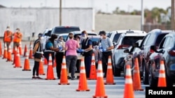 Florida Department of Health medical workers prepare to administer a COVID-19 vaccine to seniors in the parking lot of the Gulf View Square Mall in New Port Richey near Tampa, Florida, Dec. 31, 2020.