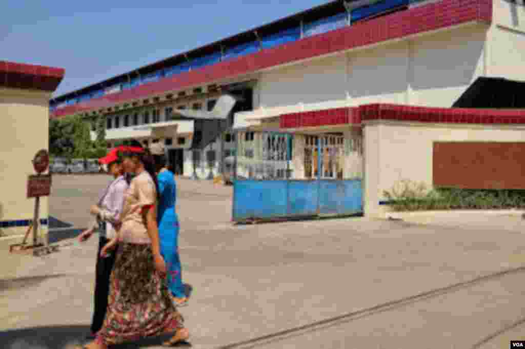 Striking workers walk past the Tai Yi footwear factory. (Steve Herman/VOA)