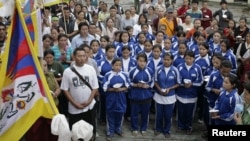 FILE - Exiled Tibetan school children sing their national anthem.