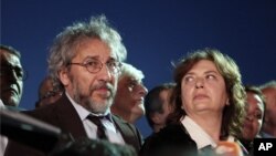 Journalist Can Dundar and his wife Dilek Dundar speak after his trial in Istanbul, late Friday, May 6, 2016. Dundar was sentenced to five years and 10 months in prison at the closed-door trial in Istanbul, while the paper's Ankara bureau chief Erdem Gul was sentenced to five years.
