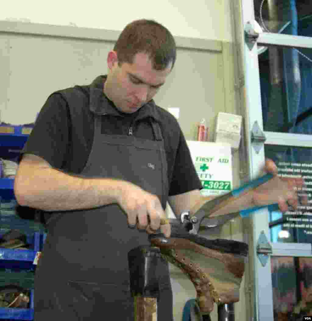 Recrafter Oleg Shyshkin begins to remove the outer sole of one of VOA correspondent Steve Herman&#39;s boots at the Danner factory in Portland, Oregon, Jan. 20, 2014. (Steve Herman/VOA) 