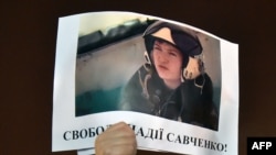 A demonstrator holds a picture of Ukranian army officer captured by pro-Russian insurgents, Nadiya Savchenko, bearing the slogan "Free Nadiya Savchenko" during a rally on Independence Square in Kiev on Jan. 26, 2015.