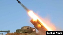 Policemen use their shields during the demolition of an informal settler community in Manila, Philippines, to redevelop the area into a business district in a joint venture with a private firm. Some 500 families were affected by the demolition.