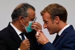 Presiden Prancis Emmanuel Macron, kanan, berbicara dengan Direktur Jenderal WHO Tedros Adhanom Ghebreyesus saat pembukaan Akademi Organisasi Kesehatan Dunia di Lyon, Prancis tengah, Senin, 27 September 2021. (Foto: Ludovic Marin via AP)