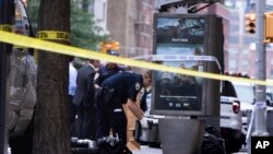 An investigator picks up a suspicious package that was thought to be an explosive device in Manhattan's Chelsea neighborhood Friday, Aug. 16, 2019, in New York. The appliance was deemed harmless and taken away as evidence.