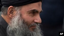 FILE - Abu Qatada arrives back at his residence in London after being freed from prison, Nov. 13, 2012.