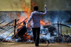 Seorang polisi membakar setumpuk ganja sitaan saat upacara di Mapolres Banda Aceh pada 23 September 2020. (Foto: AFP/Chaideer Mahyuddin)