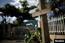 A handwritten address sign is attached to a post on a street at the squatter community of Villa Hugo in Canovanas, Puerto Rico, Dec. 9, 2017.