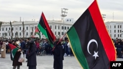 Des Libyens brandissent le drapeau national sur la place des Martyrs à Tripoli, le 17 février 2025, lors d'un rassemblement pour commémorer le 14e anniversaire du soulèvement qui a renversé Mouammar Kadhafi, l'homme fort de longue date. (Photo par AFP)