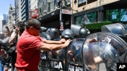 FILE - Demonstrators confront police to protest the economic reforms of Argentine President Javier Milei, outside the Supreme Court in Buenos Aires, Dec. 27, 2023.